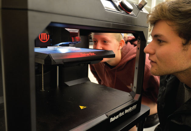 Students working with a 3D printer